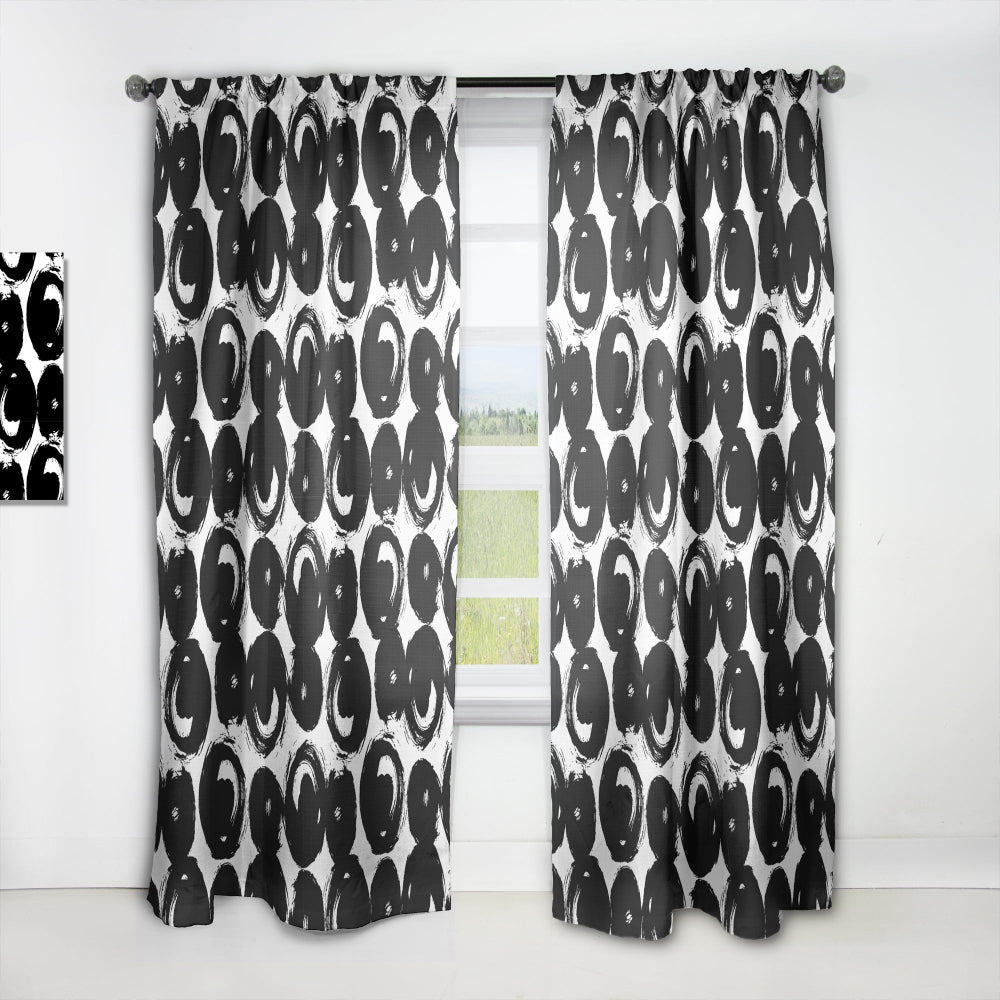 Black and white patterned curtains on a white window frame.