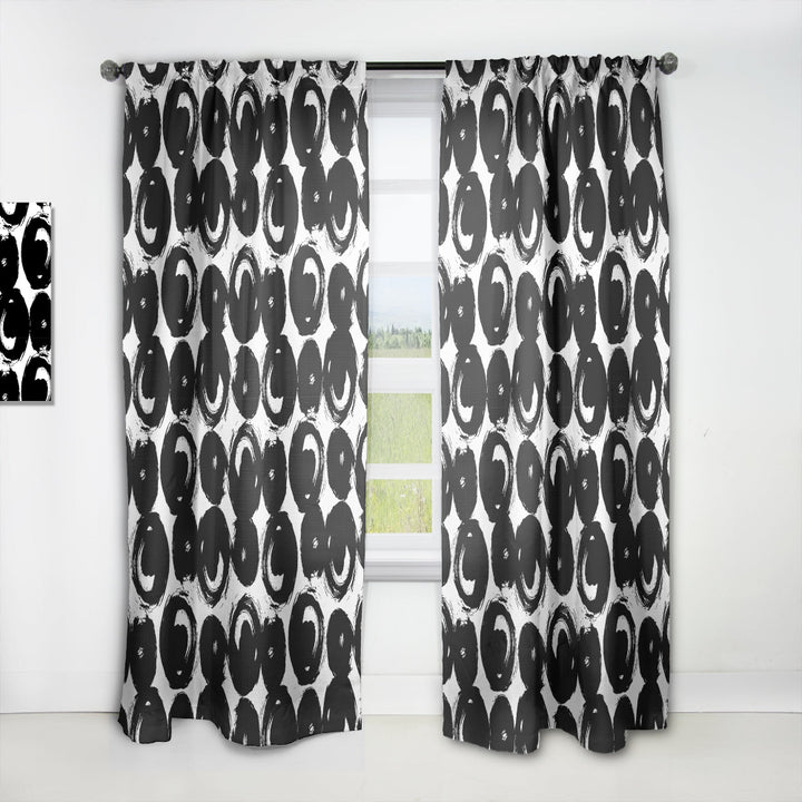 Black and white patterned curtains on a white window frame.