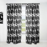 Black and white patterned curtains on a white window frame.
