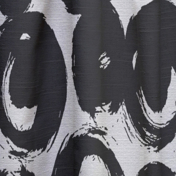 Close-up of a black and white patterned fabric with abstract shapes.