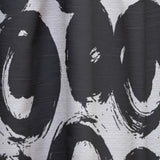 Close-up of a black and white patterned fabric with abstract shapes.
