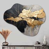 Asymmetric metal wall art featuring abstract black and gold shapes, mounted on a wall with a shelf and decorative objects in the foreground.